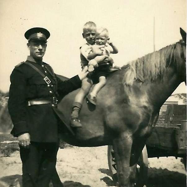 politieman naast paard met een kindje op de rug van het paard